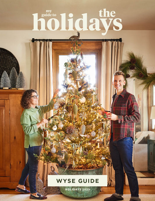 Kaleb Wyse wearing plaid shirt standing beside Christmas tree with mom Jodi to the side.