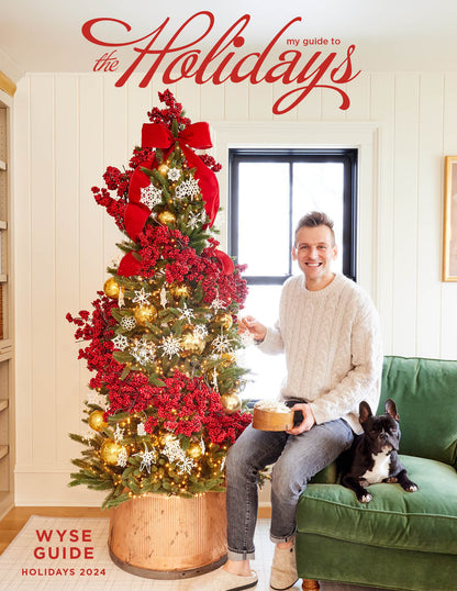 Magazine cover of 2024 holiday magazine with Kaleb Wyse putting decor on a Christmas tree.