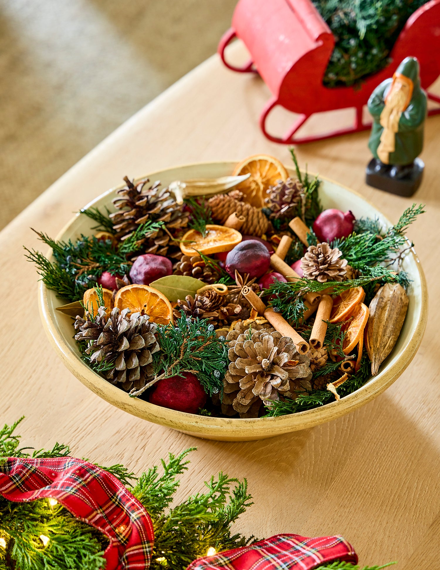 Decorative bowl filled with Christmas potpourri on a wooden surface.