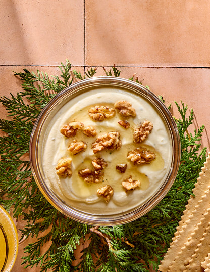 Bowl with whipped ricotta with walnuts and honey on top.